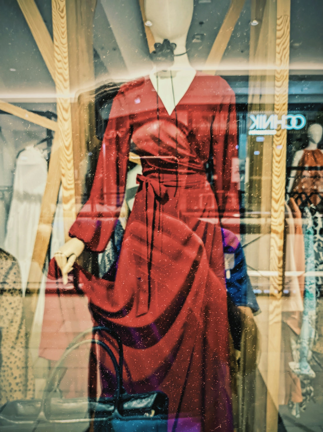 A mannequin dressed in a red dress in a store window